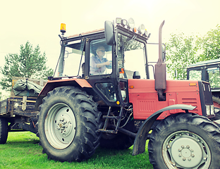 Image showing senior man driving tractor at farm