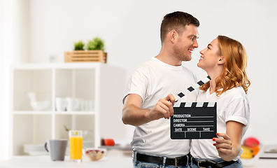 Image showing happy couple in white t-shirts with clapperboard