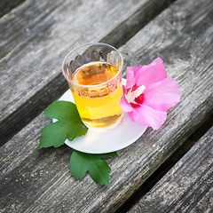 Image showing Mallow tea with blossom on old wooden background