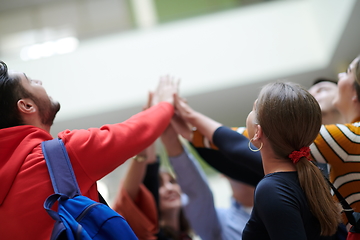 Image showing students together in problem, arm in the air