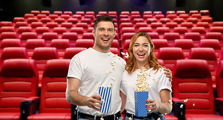 Image showing happy couple in t-shirts with popcorn at cinema