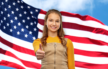 Image showing teenage girl showing thumbs up over american flag