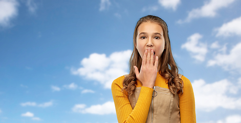 Image showing teenage girl closing her mouth by hand or yawning