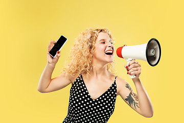 Image showing Caucasian young woman\'s half-length portrait on yellow background