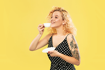 Image showing Caucasian young woman\'s half-length portrait on yellow background