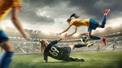 Image showing Female soccer or football players kicking ball at the stadium