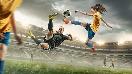 Image showing Female soccer or football players kicking ball at the stadium