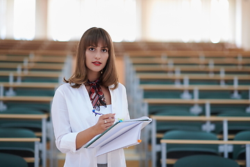 Image showing famale student using pen and notebook