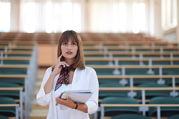 Image showing famale student using pen and notebook