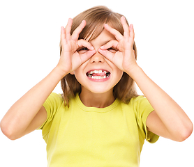 Image showing Happy little girl is showing glasses gesture