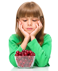 Image showing Cute girl doesn\'t want to eat cherries