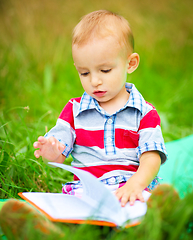 Image showing Little boy is reading book