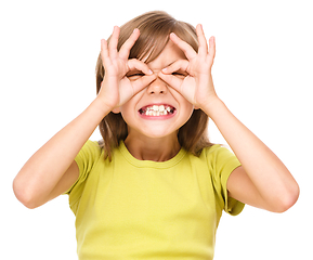 Image showing Happy little girl is showing glasses gesture