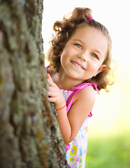 Image showing Cute little girl is playing hide and seek