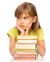 Image showing Little girl with a pile of books