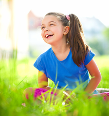 Image showing Portrait of a little girl sitting on green grass
