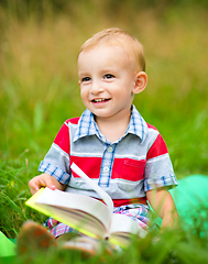 Image showing Little boy is reading book