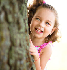 Image showing Cute little girl is playing hide and seek