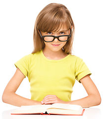 Image showing Little girl is reading a book