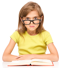 Image showing Little girl is reading a book