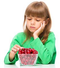Image showing Cute girl doesn\'t want to eat cherries