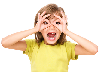 Image showing Happy little girl is showing glasses gesture