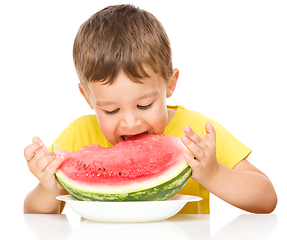 Image showing Little boy is eating watermelon