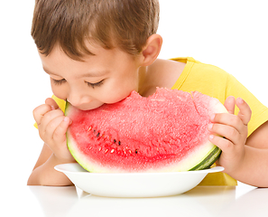 Image showing Little boy is eating watermelon