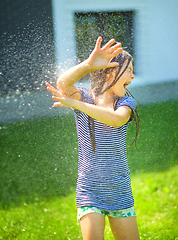 Image showing Happy girl is playing under rain