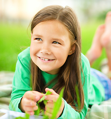 Image showing Portrait of a little girl laying on green grass