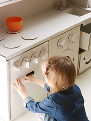 Image showing toddler girl playing with toy kitchen at home