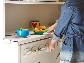 Image showing Child girl playing with toy kitchen at home