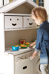 Image showing toddler girl playing with toy kitchen at home