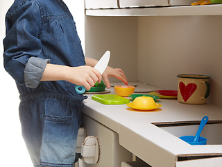 Image showing Child girl playing with toy kitchen at home