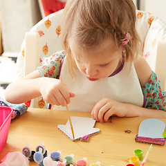 Image showing Cute little girl painting on home interior background