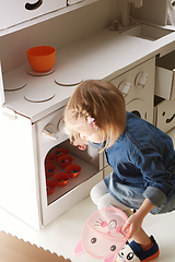 Image showing toddler girl playing with toy kitchen at home