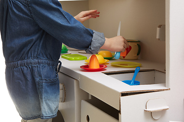 Image showing Child girl playing with toy kitchen at home