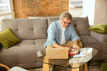 Image showing Senior man working with laptop at home - concept of home studying