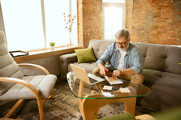 Image showing Senior man working with laptop at home - concept of home studying