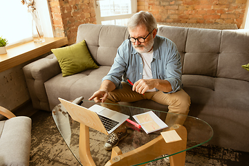 Image showing Senior man working with laptop at home - concept of home studying