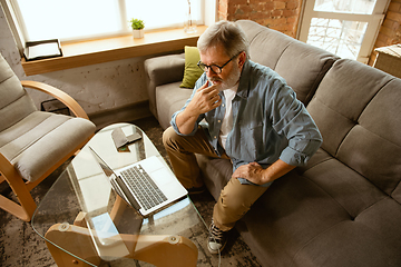 Image showing Senior man working with laptop at home - concept of home studying