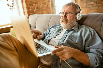 Image showing Senior man working with laptop at home - concept of home studying