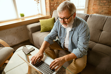 Image showing Senior man working with laptop at home - concept of home studying