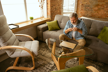 Image showing Senior man working with laptop at home - concept of home studying