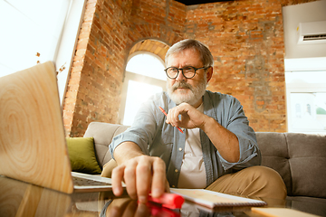 Image showing Senior man working with laptop at home - concept of home studying