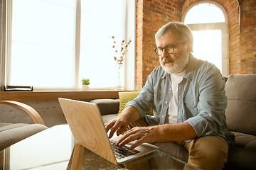 Image showing Senior man working with laptop at home - concept of home studying