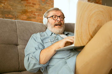 Image showing Senior man working with laptop at home - concept of home studying