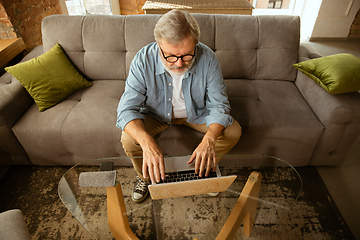 Image showing Senior man working with laptop at home - concept of home studying