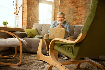 Image showing Senior man working with laptop at home - concept of home studying