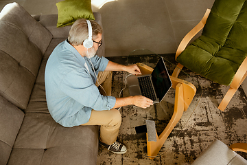 Image showing Senior man working with laptop at home - concept of home studying